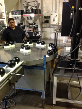 Hollow plastic shade balls on production line at XavierC LLC manufacturing facility.